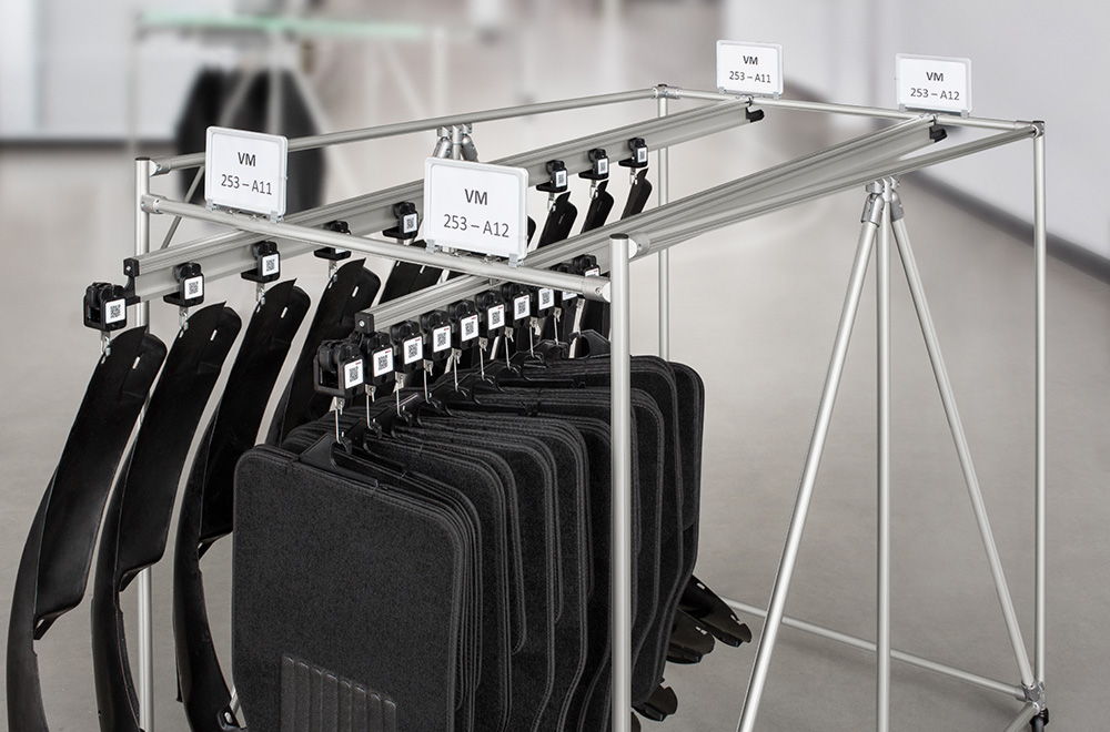 Integration of the item suspended conveyor system into transport trolleys or racks