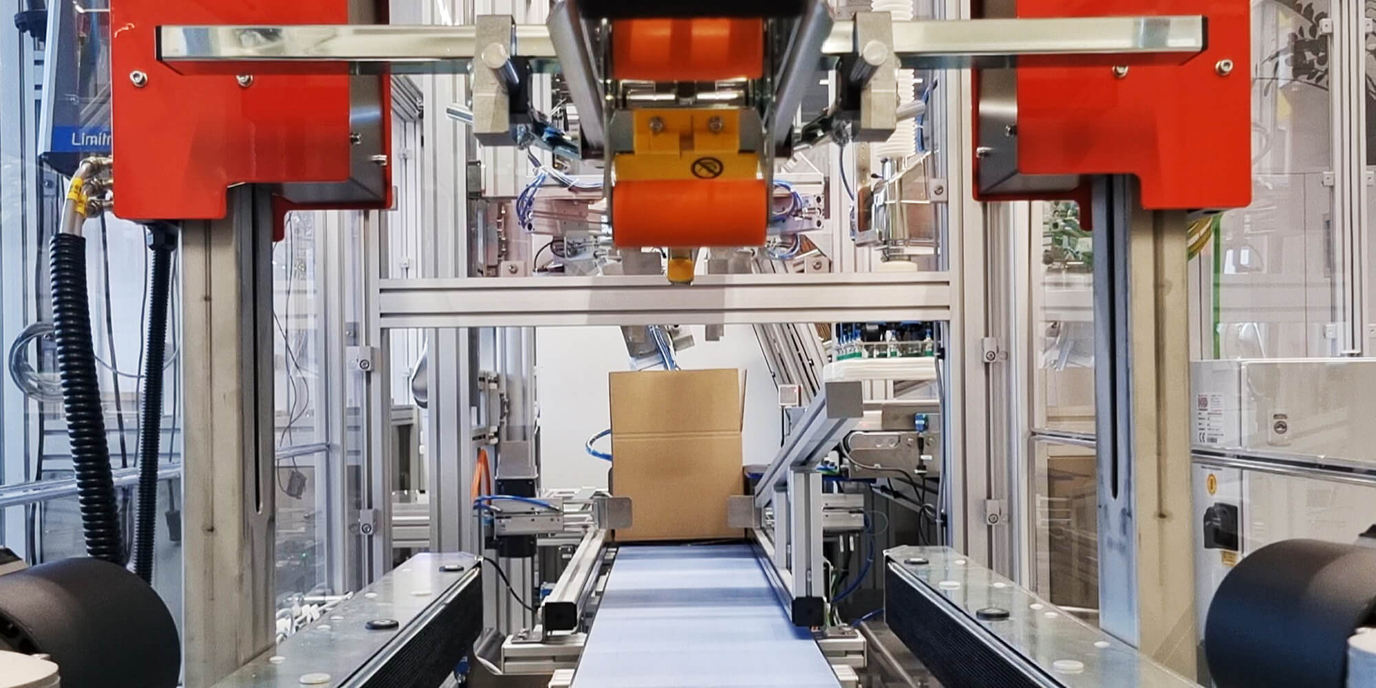 Packaging system sealing station with a box on a conveyor belt
